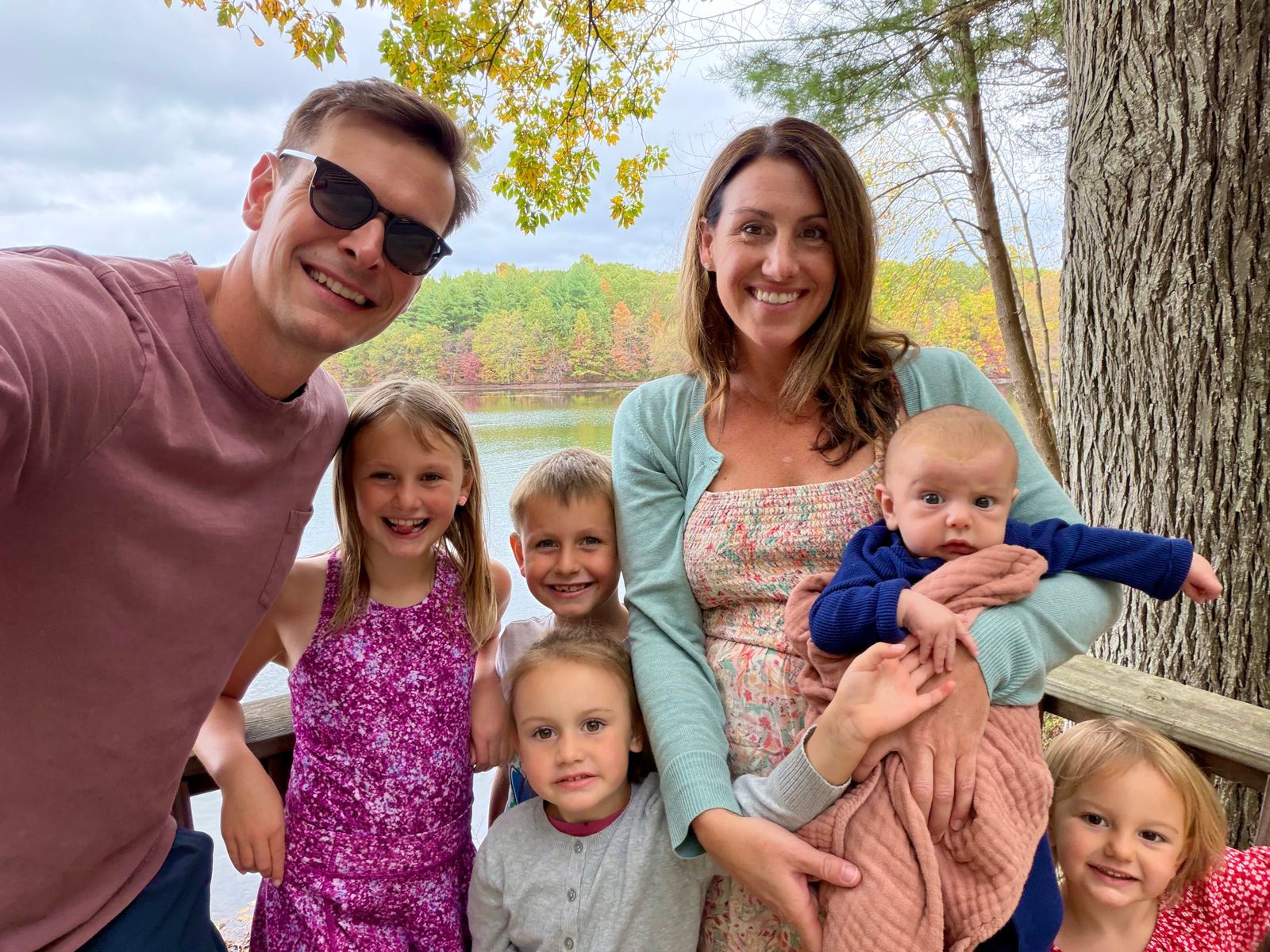 Ashley and Brian with their five children on a lakeside deck in autumn